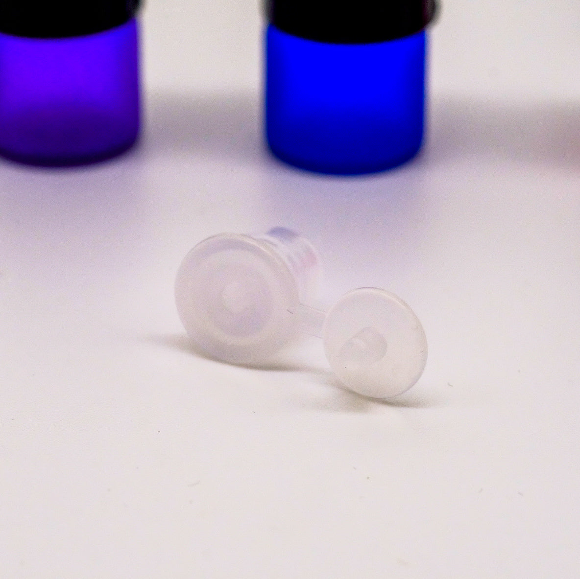 Bouteilles d'échantillonnage de 1 ml avec capuchon noir et réducteur d'orifice, conçues pour prévenir les fuites et faciliter l'application des huiles essentielles.