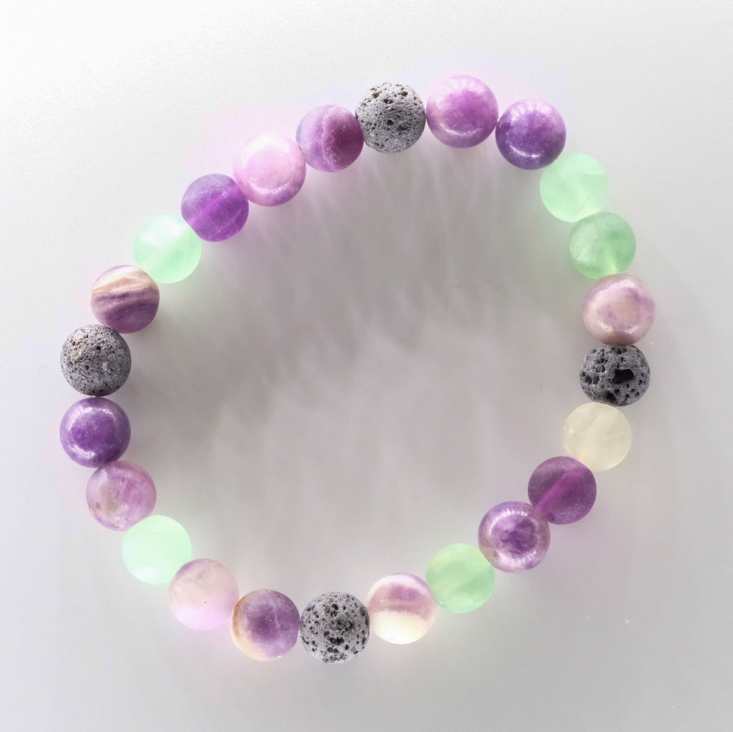 Bracelet diffuseur d'huiles essentielles modèle Lagune, fait à la main au Québec avec des pierres naturelles de fluorite givrée et lépidolite, disponible chez Essanzia.
