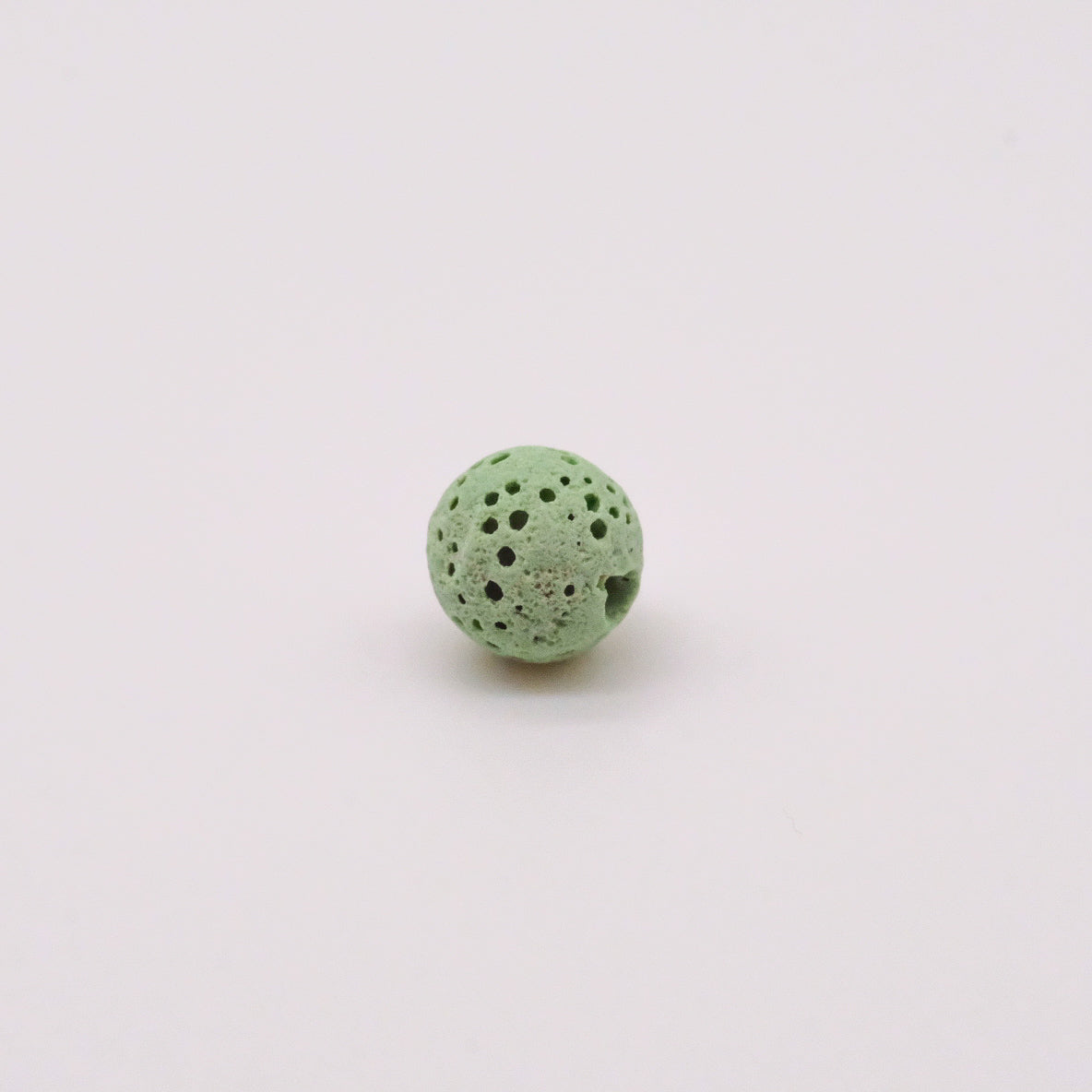 Pierres de lave colorées disponibles en plusieurs teintes, idéales pour absorber et diffuser des huiles essentielles dans des colliers diffuseurs, proposées par Essanzia.