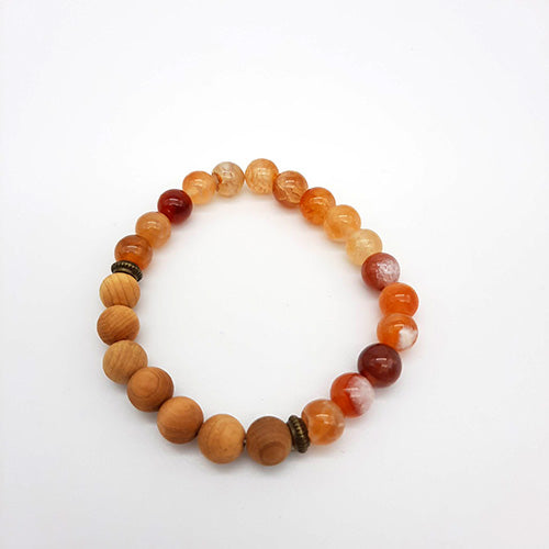Bracelet diffuseur d'huiles essentielles en pierre volcanique et perles de bois, version orange, ajoutant une touche de couleur vive tout en offrant les bienfaits de l'aromathérapie, accessoire idéal pour les amateurs d'huiles essentielles.
