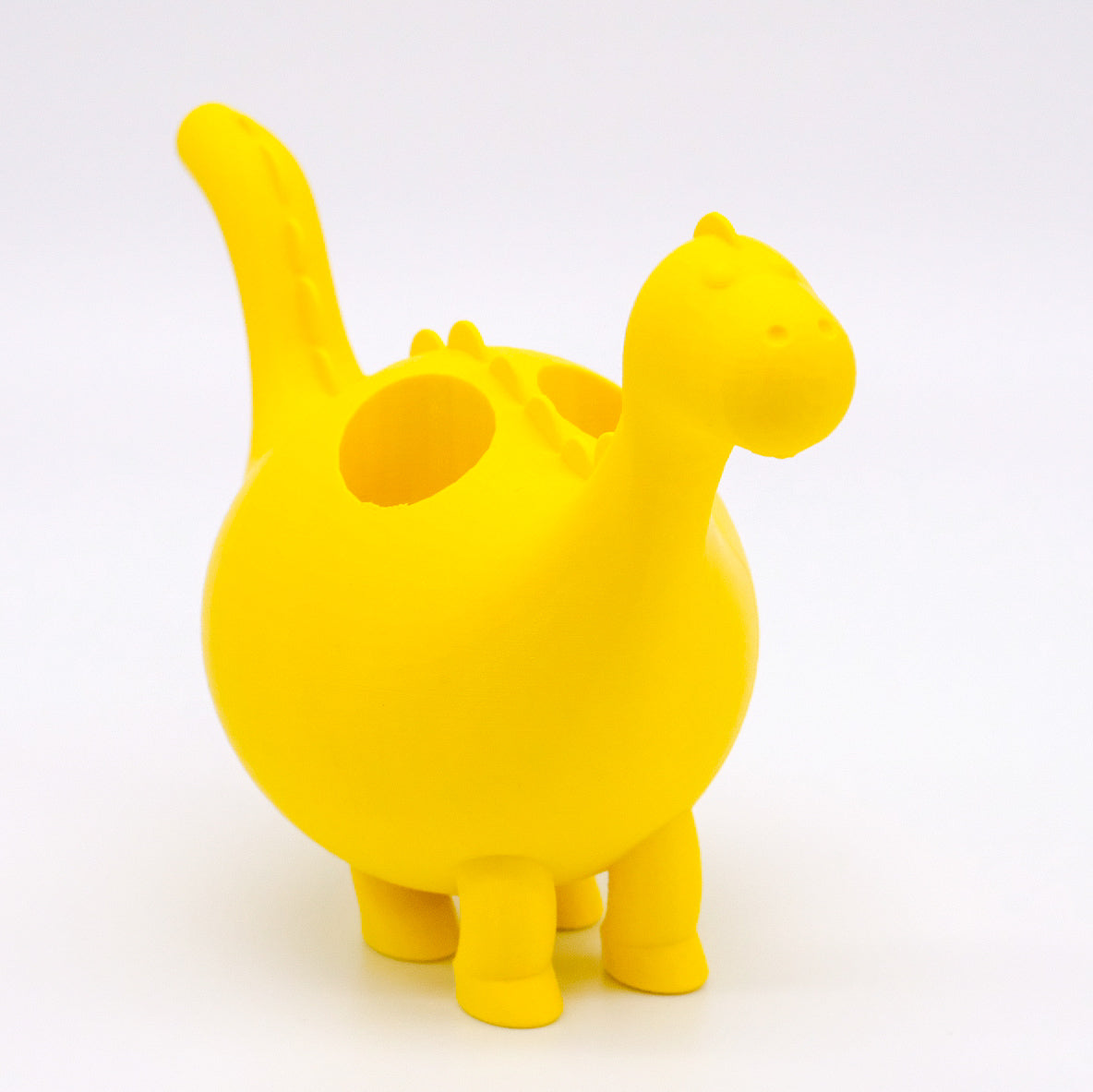 Présentoir en forme de dinosaure jaune, imprimé en 3D, conçu pour contenir des bouteilles d'huiles essentielles de 10 ml, ajoutant une touche ludique et colorée à votre espace, disponible chez Essanzia.