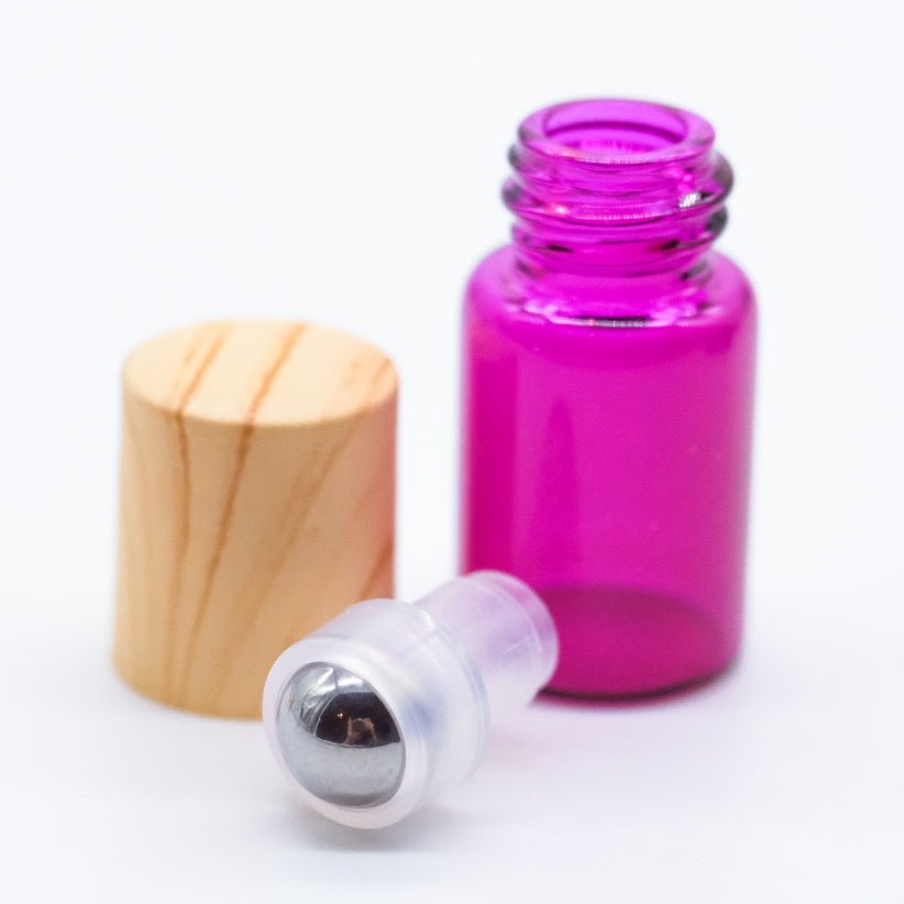 Flacon en verre coloré avec bouchon en bois, bille en acier inoxydable et embout en plastique, conçu pour l'application d'huiles essentielles en rouleau à bille.