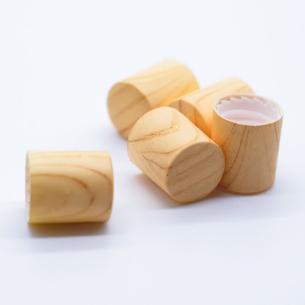 Bouchons en bois avec intérieur en plastique, conçus pour des flacons d'huiles essentielles. Offrent une finition naturelle et une fermeture hermétique.