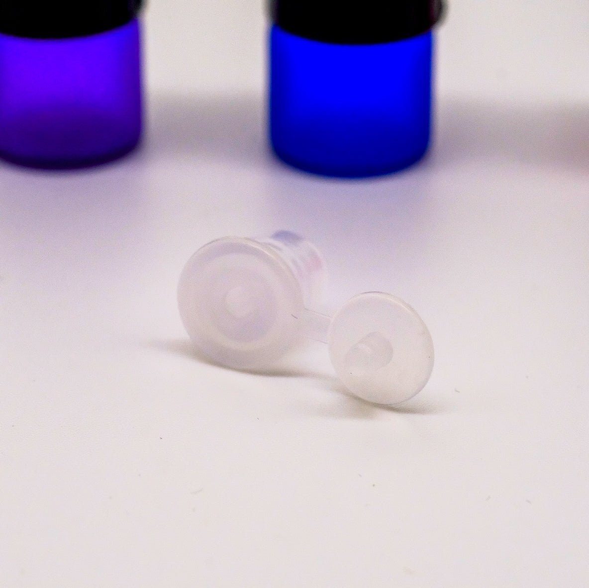 Bouteilles d'échantillonnage de 1 ml avec capuchon noir et réducteur d'orifice, conçues pour prévenir les fuites et faciliter l'application des huiles essentielles.