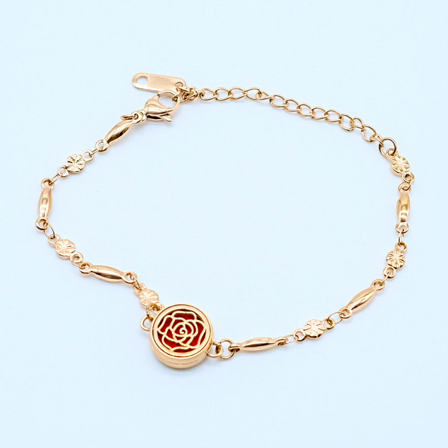 Bracelet diffuseur en acier inoxydable dore avec motif de rose, incluant un compartiment pour tampons impregnes d’huiles essentielles, elegant et raffine pour le bien-etre quotidien.