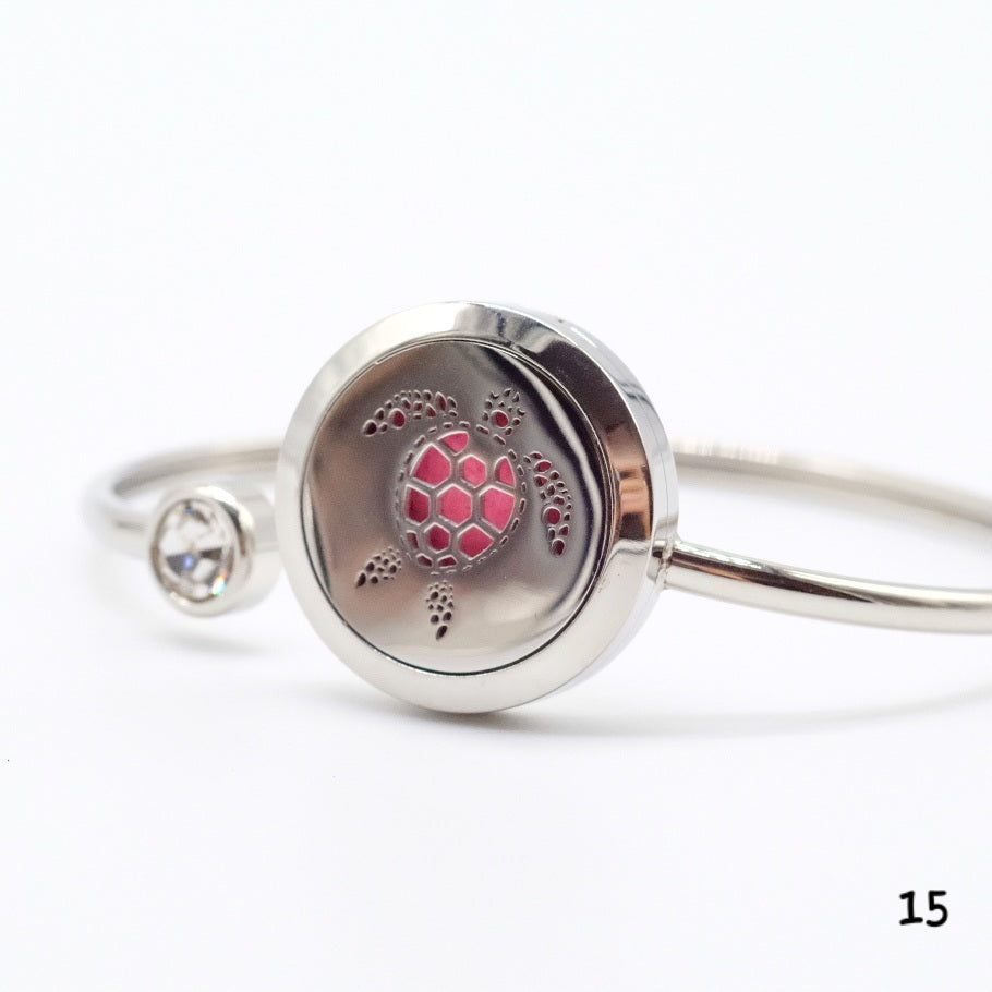 Bracelet diffuseur en acier inoxydable avec motif de tortue, intégrant un compartiment pour tampons imprégnés d’huiles essentielles, idéal pour associer bien-être et design marin.