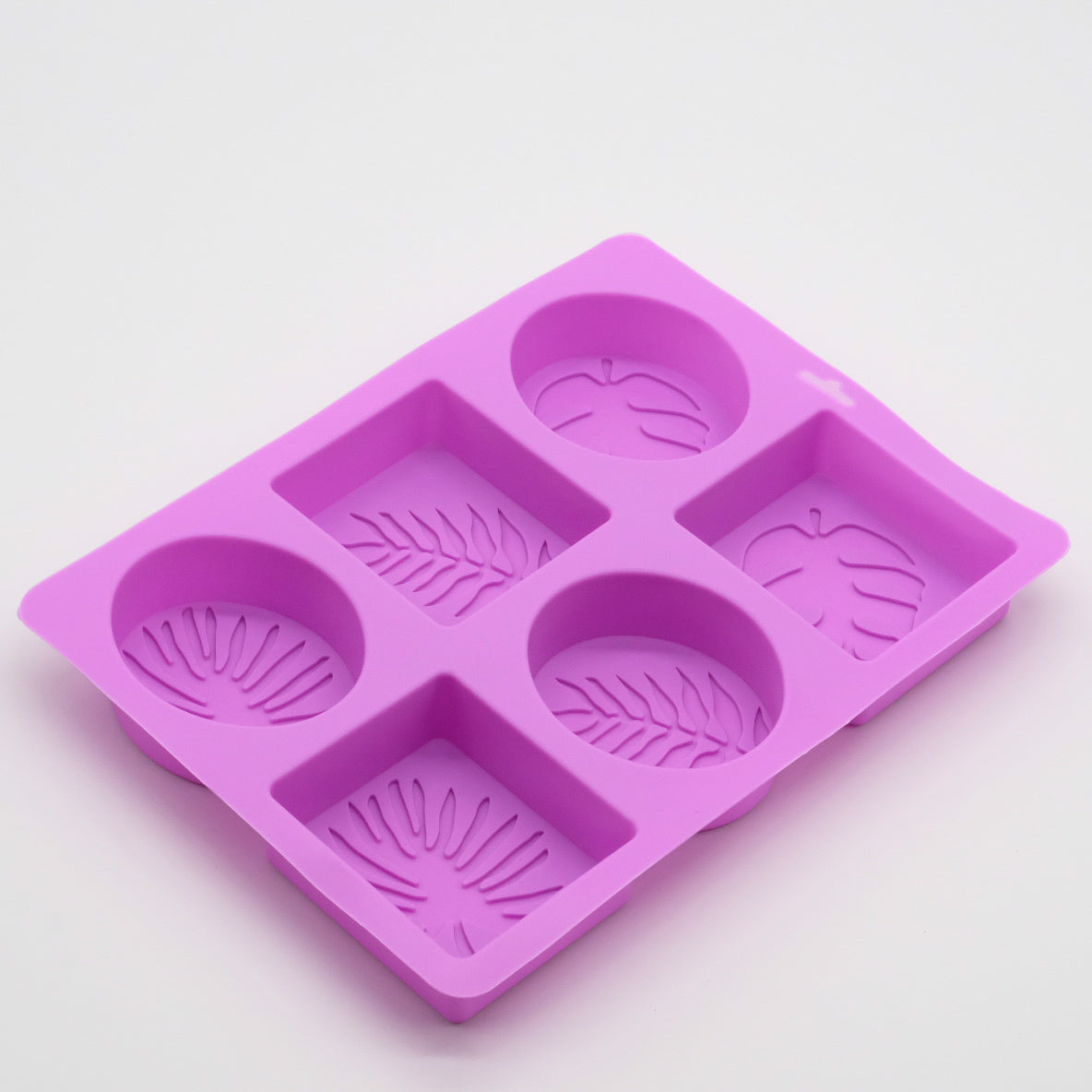 Moule en silicone violet avec 6 empreintes mixtes (3 rondes, 3 carrées) à motifs de feuilles tropicales.
