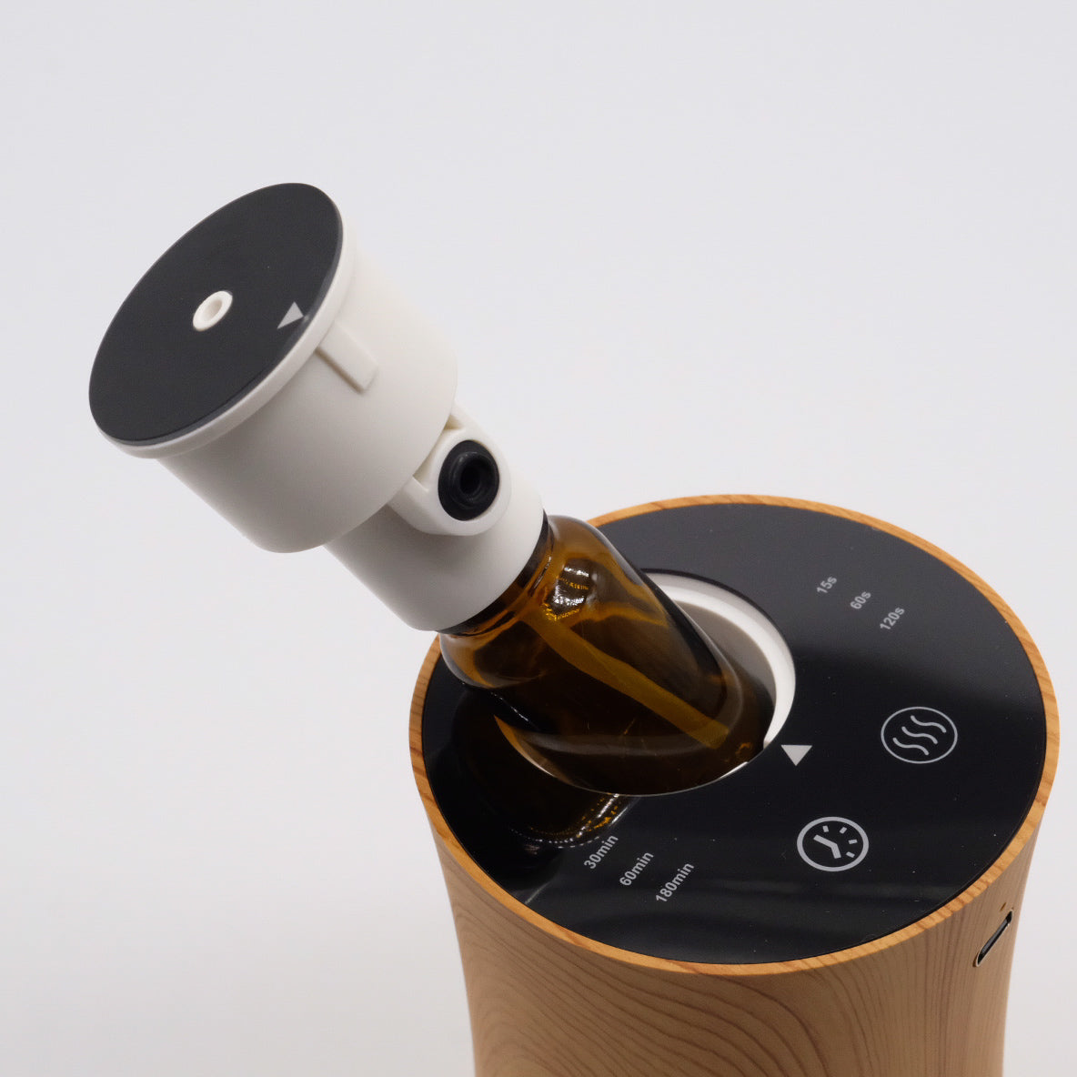 Nébulisateur effet bois, bouteille ambrée insérée avec adaptateur blanc, vue du dessus avec icônes de minuteur.